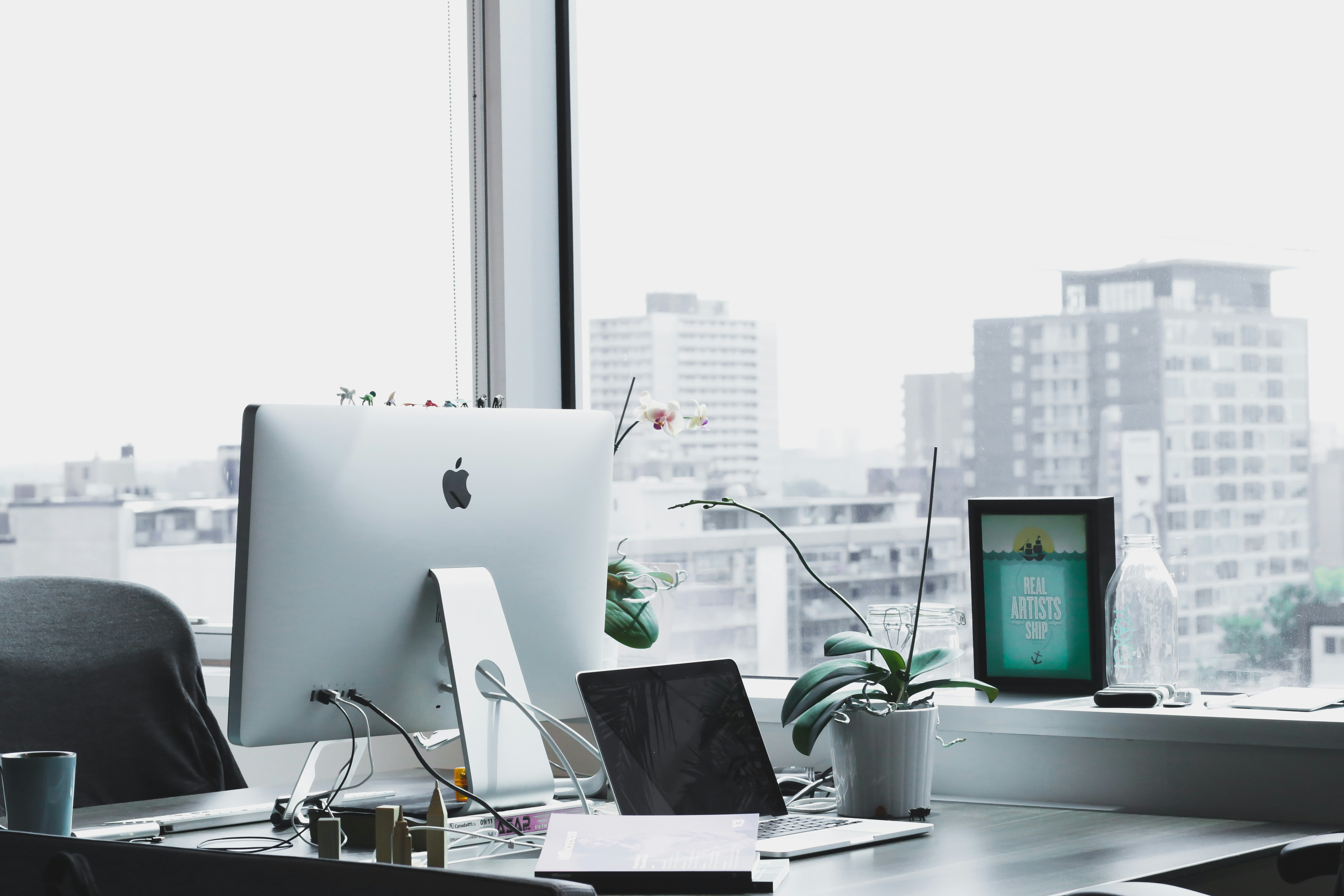 A tidy business workspace with a laptop, website screen, and IT equipment. Photograph by Alesia Kazantceva.